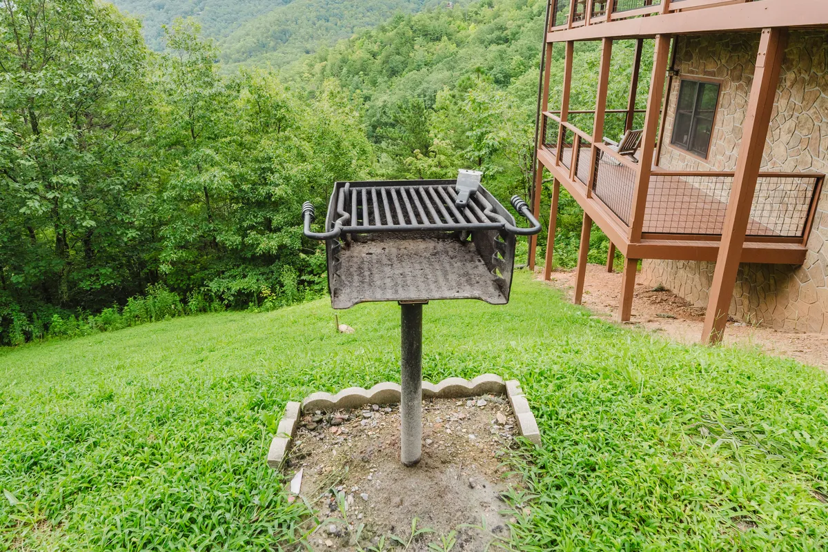 This image presents a lush, green patio area with a charcoal grill as the focal point, ideal for barbecues and al fresco dining. The inviting grill space suggests memorable social gatherings and fresh air feasts as described in the section content.